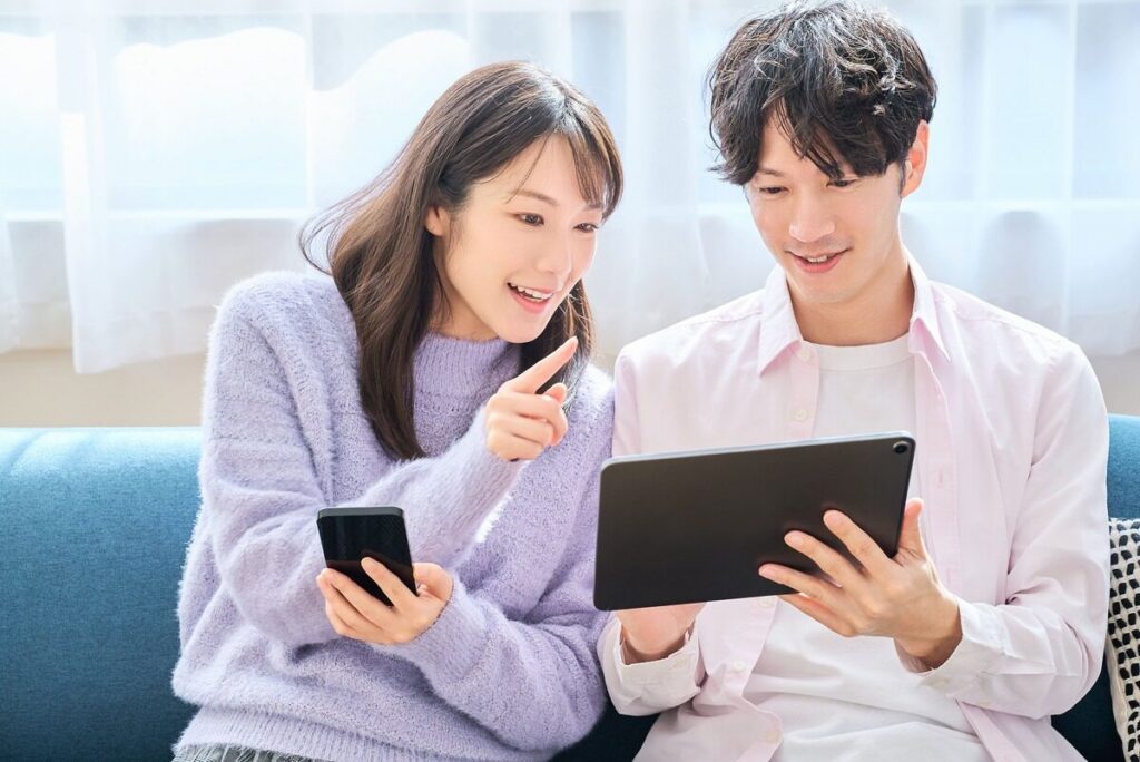 タブレットを一緒に見ている若い男性と女性