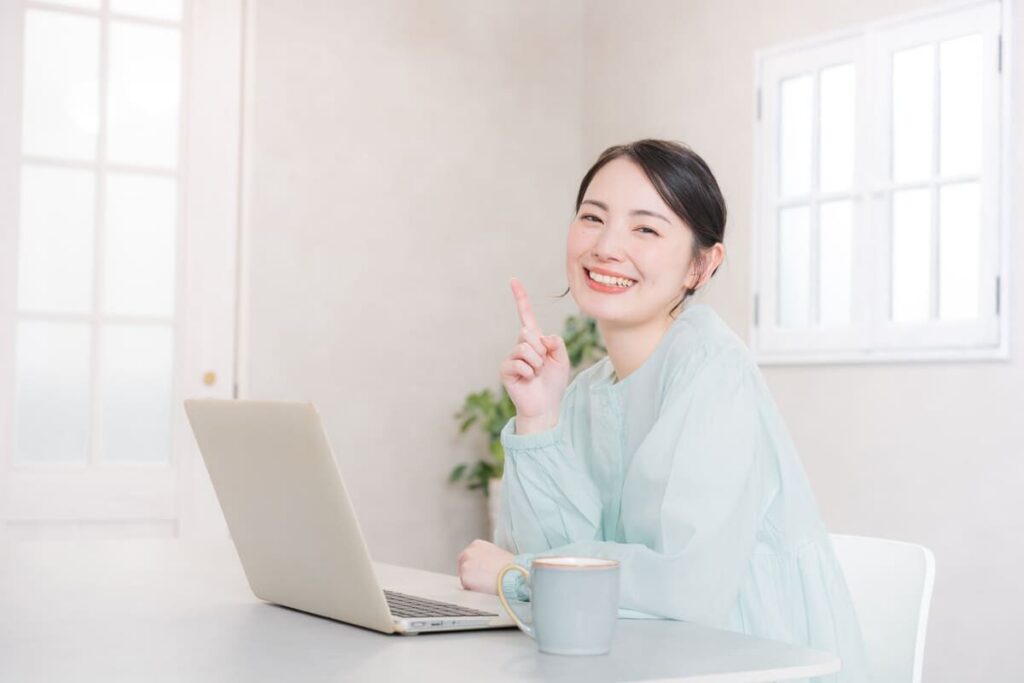 指でサインする笑顔の女性