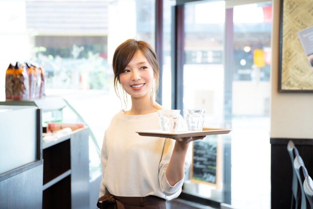 飲食店でドリンクを運ぶ女性スタッフ